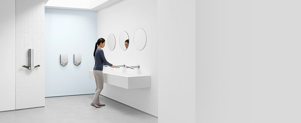 Жена, която суши ръце си с Dyson Airblade Wash+Dry